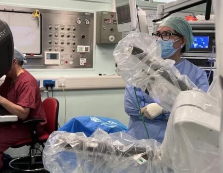 Staff performing surgery with robot
