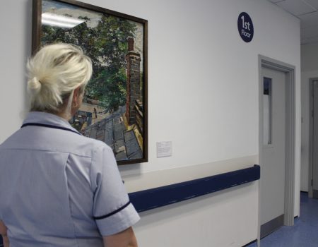 member of staff looking at a painting