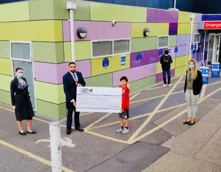 school teacher presenting a cheque at the L&D hospital