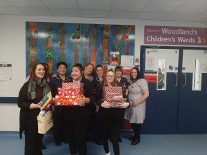 School children posing with staff from our Children's Ward with Christmas gifts