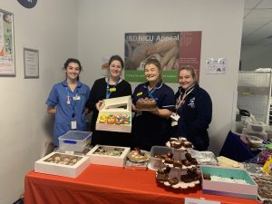 Members of staff at a cake sale stand