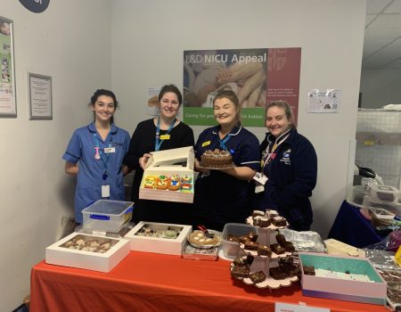 Members of staff at a cake sale stand