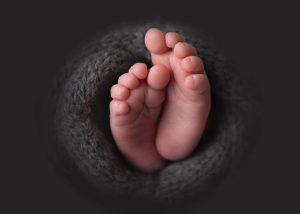 An image of a babies feet surrounded by wool texture