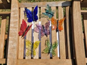 A selection of glass butterflies on a bench