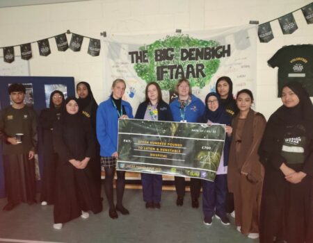 Students and school staff presenting the charity with a cheque