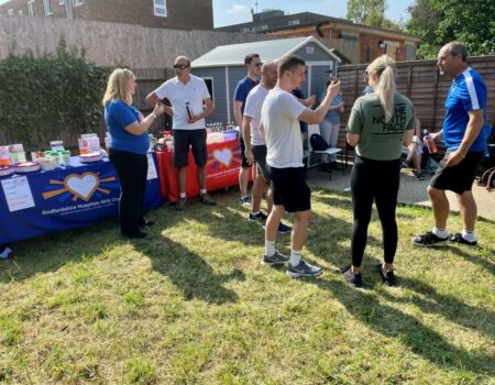 People gathered next to a charity stand