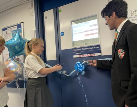 A student cutting the ribbon