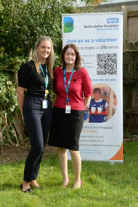 Sabine and Mhairi in front of the volunteering banner