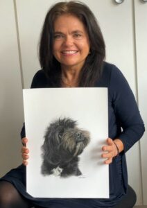 Karen Reep holding a painting of a dog