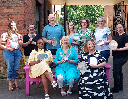 Staff at a creative workshop holding their metal figures