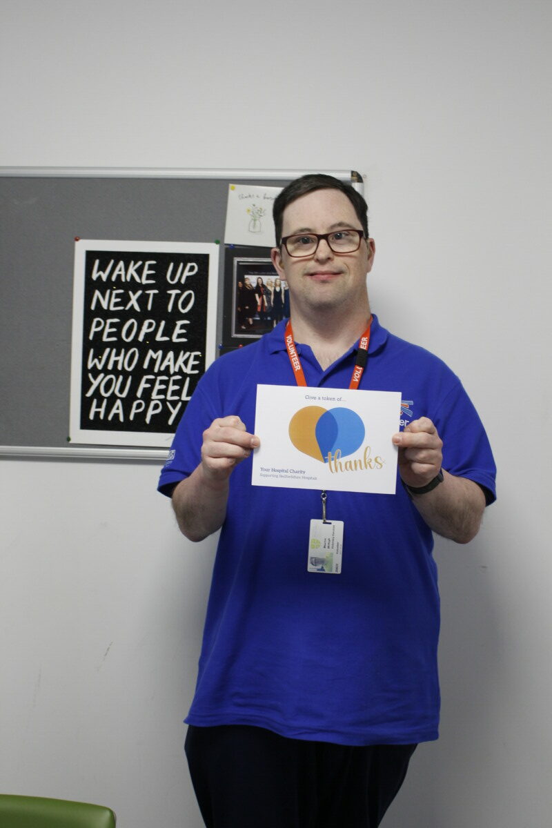 Charity team member with a 'Thank you' sign