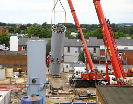 Chimney flue being lifted to position by crane
