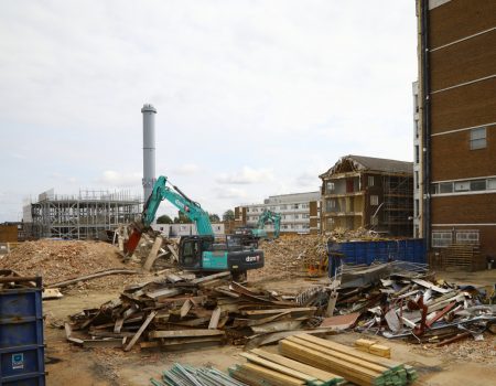 Digger demolishing buildings on construction site