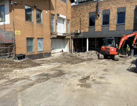 Outside progress picture with digger demolishing old building