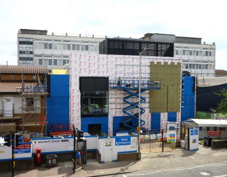 Photo of emergency department wall upgrades with men standing in crane