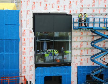 Men standing on crane next to wall redevelopment