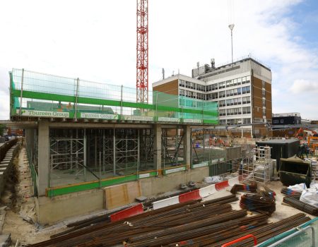 Photo of redevelopment site with crane in the centre and buildings in the background