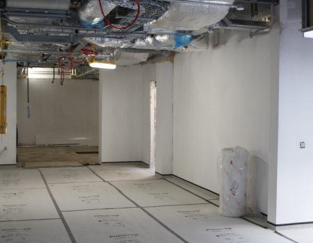 Interior of emergency department upgrades with white walls and equipment and wiring in ceiling