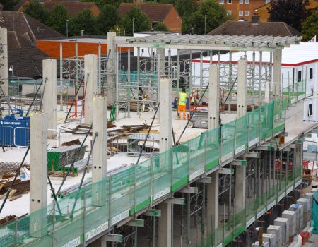 Acute services block building being upgraded with green fencing