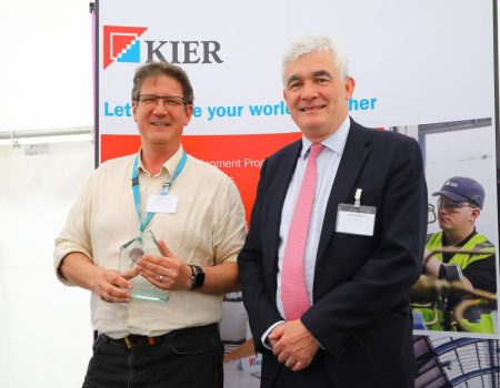 Kyle holding a glass trophy with Andrew