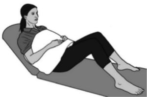 A woman leaning backwards with a pillow resting over her lap