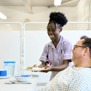 HCSW giving a meal to a patient