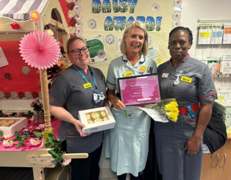 Melanie receiving her award from Louise and Marva