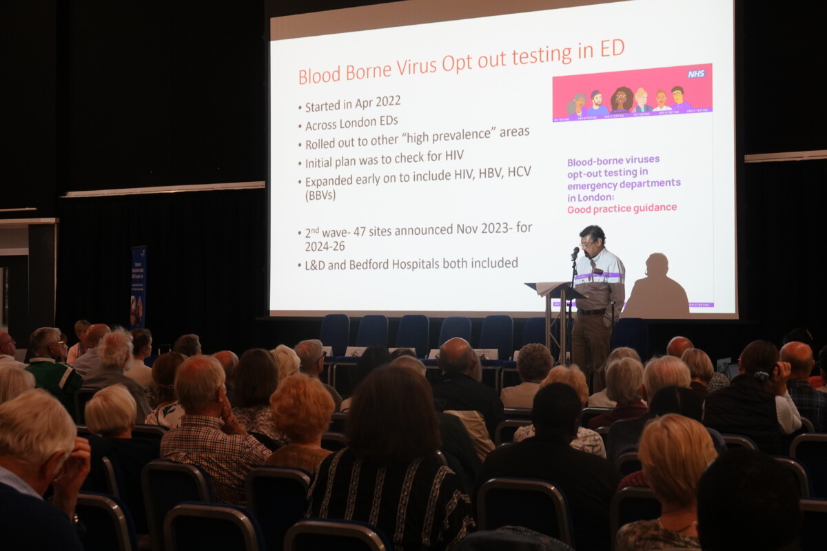 Hall filled with audience listening to a presentation on 'Blood borne virus opt out testing in ED'